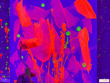 Peintre projetant de la peinture sur une grande toile posée au sol dans un atelier, illustration de l'action painting